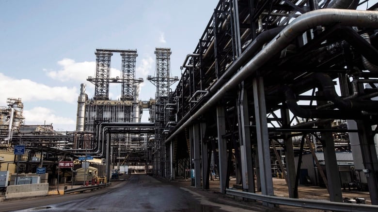 An industrial complex of pipes and a road make up an upgrader at Suncor's oil sands base plant in Fort McMurray Alta.