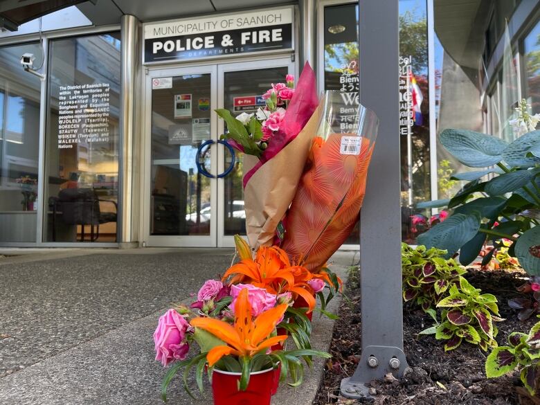 Flowers from members of the public are seen on Thursday, June 30, 2022 outside the entrance of Saanich Police Department, after six officers were wounded in a bank robbery two days earlier.