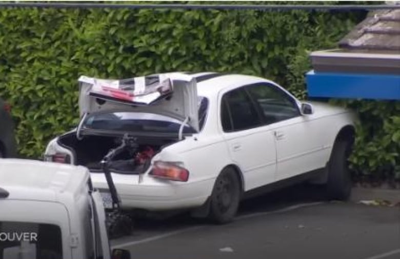 A car police identified as a white four-door 1992 Toyota Camry with black racing stripes over the hood and roof is seen in Saanich, B.C. on Tuesday, June 28, 2022. Police say the car was associated with the suspects and are asking for any public tips.