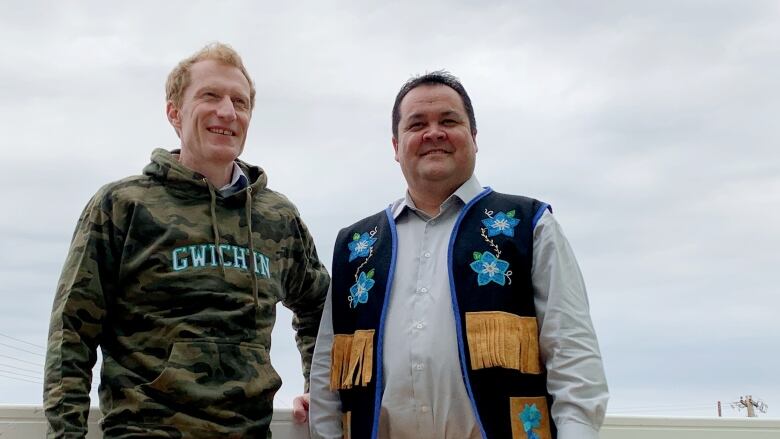 A portrait of two smiling people outside.