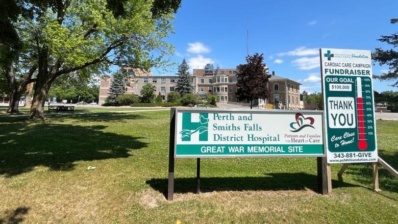 A hospital with its sign in the foreground.