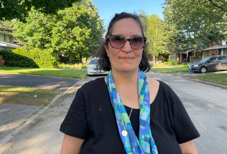 A woman in sunglasses poses for a photo.