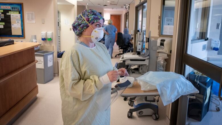 A nurse wearing personal protective equipment prepares to enter a patients room in the intensive care unit at North York General Hospital on May 26, 2020.