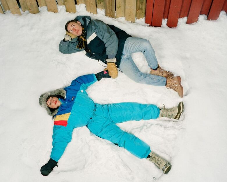 Two people lay on snow.