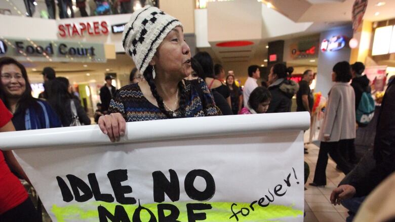 Kat Norris holds an Idle No More banner and speaks at an Indigenous rights protest and round dance she helped organize at Park Royal mall in West Vancouver, B.C. on Dec. 24, 2012, as part of Canada-wide events.