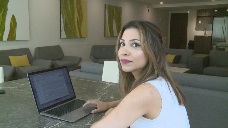 Tiana Sharifi, founder of Sexual Exploitation Education, sits indoors at a laptop computer that displays part of a research study she co-authored with Simon Fraser University's International CyberCrime Research Centre looking at new ways to detect human trafficking online using artificial intelligence.