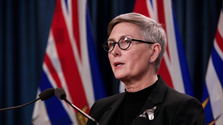 A woman with short blond hair and glasses. 