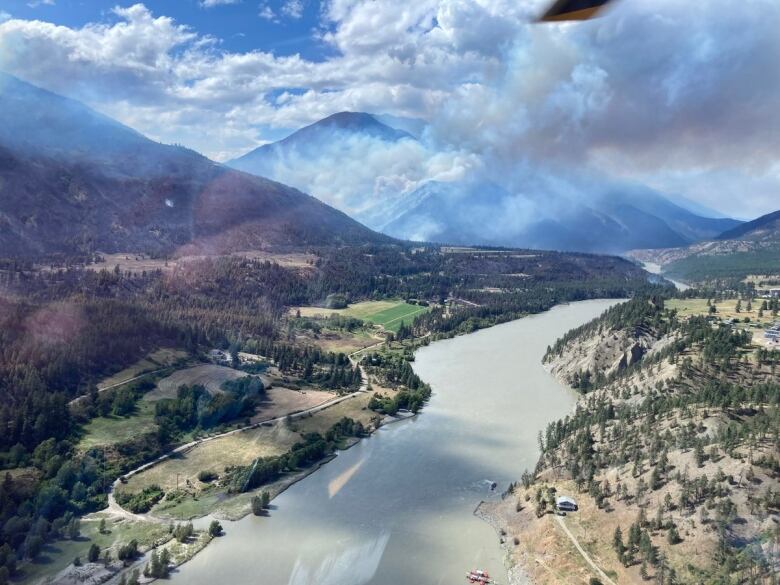 The Nohomin Creek wildfire and local river is seen in an aerial photograph 1.7 km northwest of Lytton B.C. on Saturday, as smoke rises in the mountainous distance.