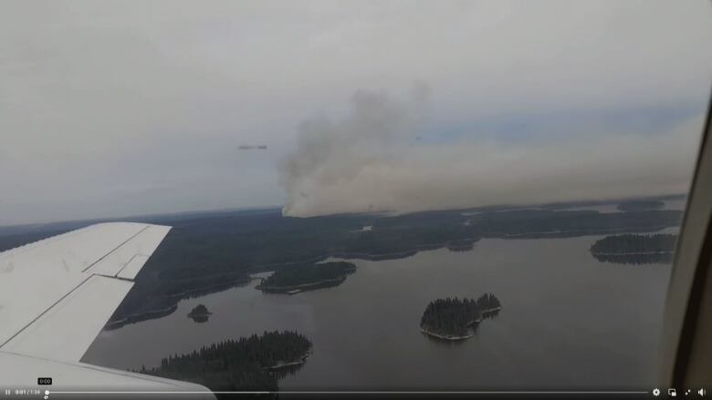 Aerial view of smoke rising over land.