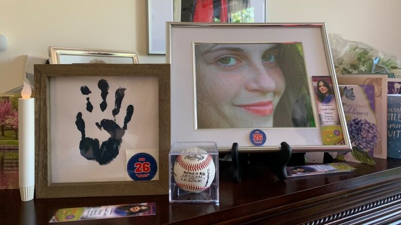 A photo of a girl on a mantelpiece.