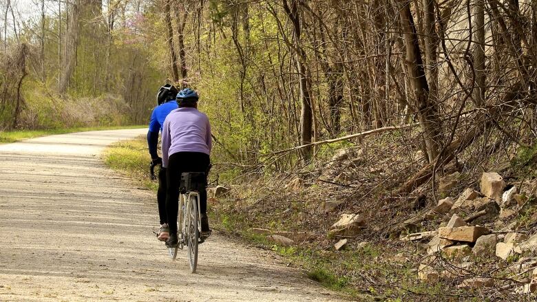 A man and women riding a bike close to one another on a path.