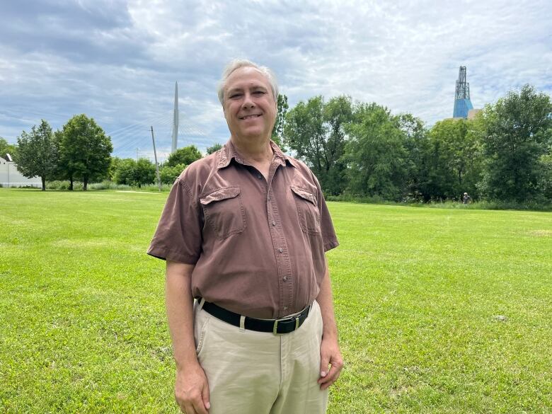 A man smiles in an open field.