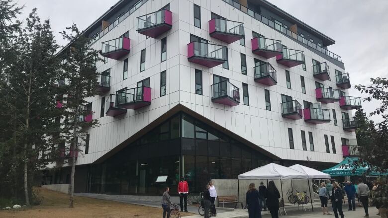 Some people gather in front of a new building.