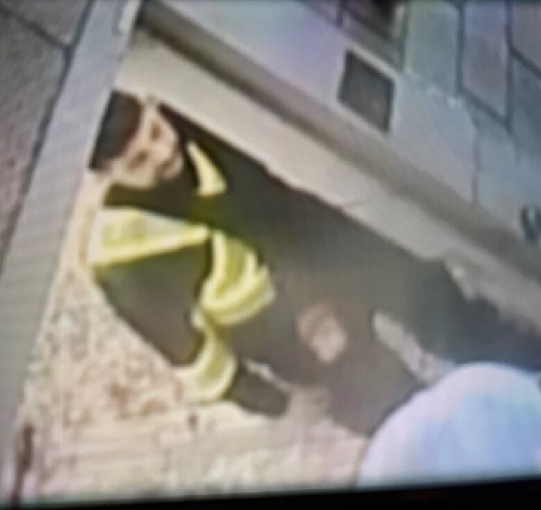 Security camera footage of Rabih Alkhalil in a high-vis vest. He is seen to be exiting a door.