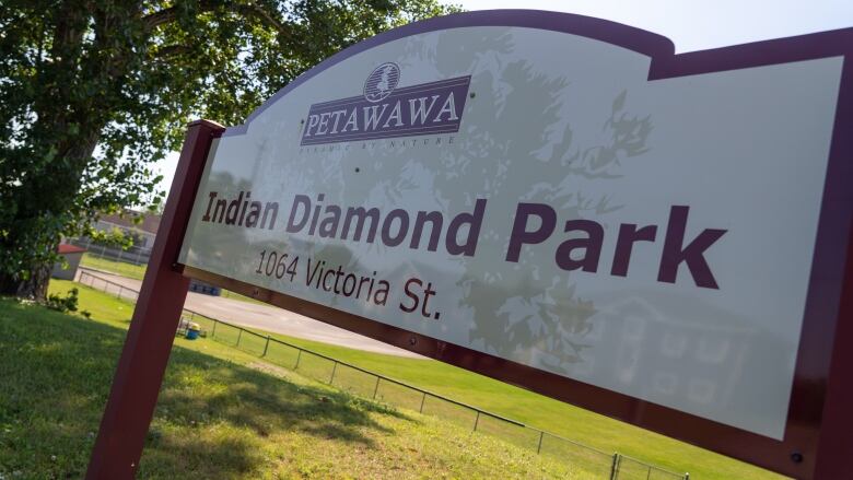 A red and white sign reads Indian Diamond Park, and a baseball diamond is in the background.