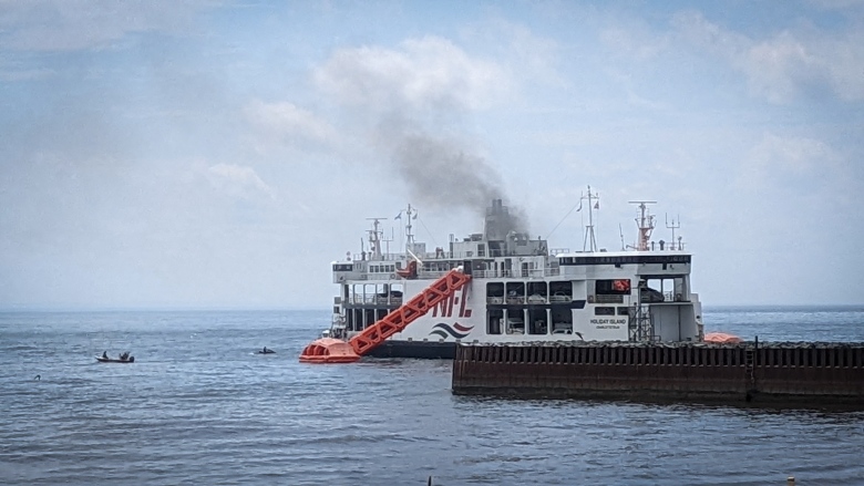 The MV Holiday Island is pictured with smoke billowing from it. 