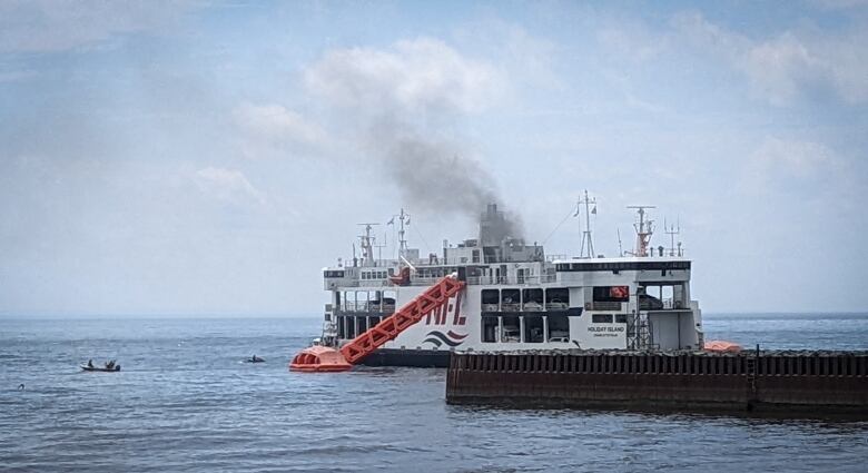 The MV Holiday Island is pictured with smoke billowing from it. 