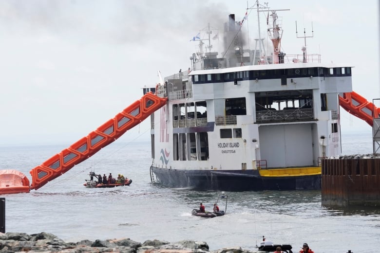 Fire fighters approach the MV Holiday Island ferry after a fire broke out on it.