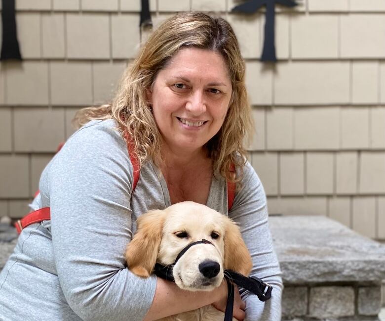 Woman poses with dog.