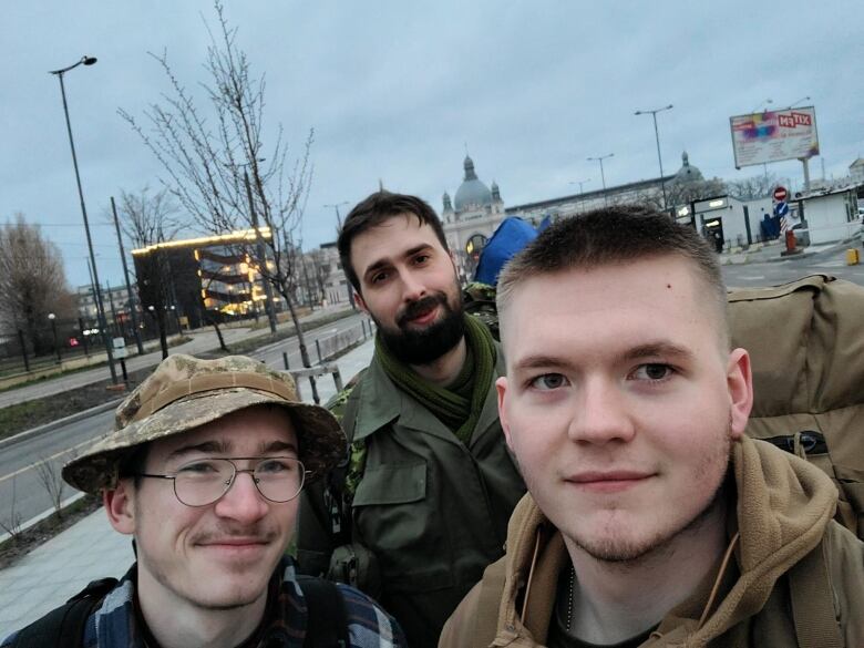 Three men dressed in army gear pose photo. 