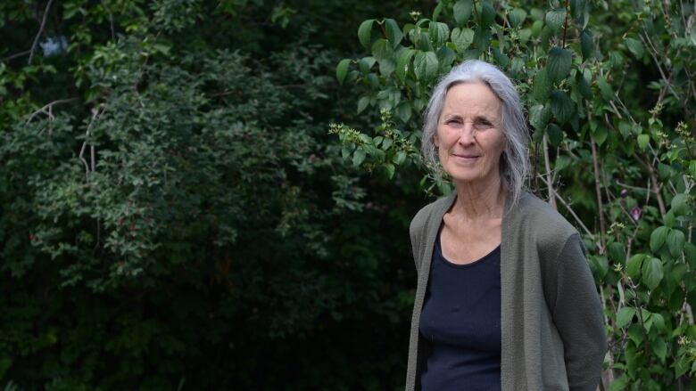 woman in front of bushes