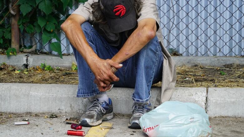 A man takes a rest in an empty parking lot in London, Ont. 