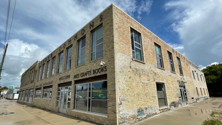 The brick exterior of a building is shown, with a sign reading 