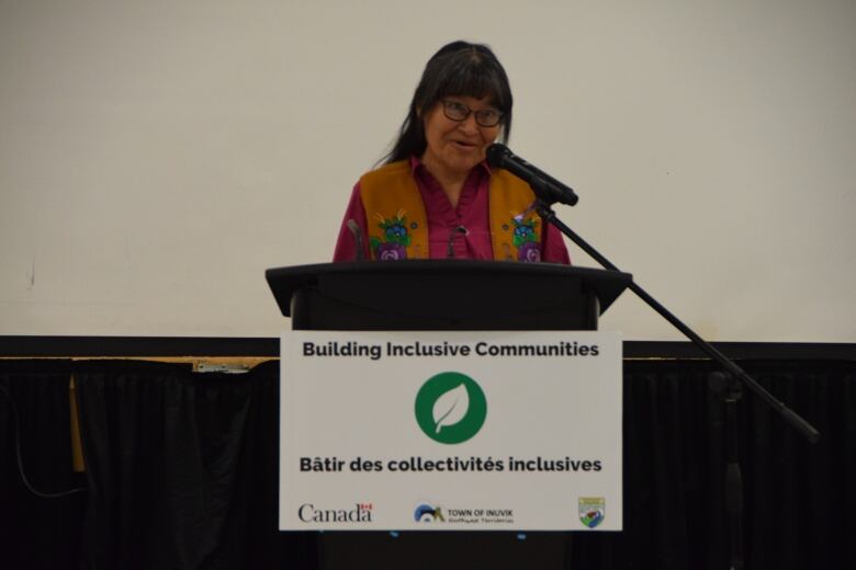 A woman speaks at a podium.