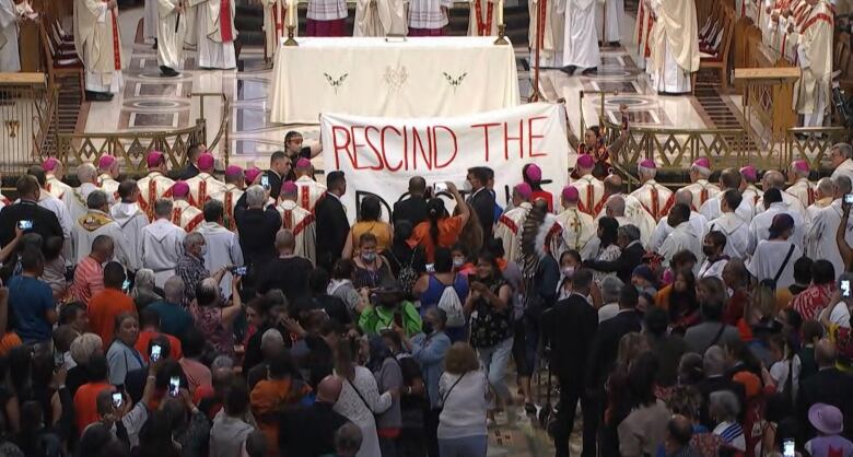 Batchewana First Nation members Chelsea Brunelle and Sarain Fox unveiled a banner on July 28, 2022 during a mass led by Pope Francis near Quebec City.