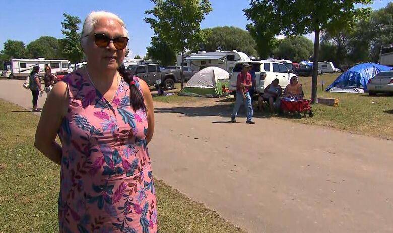 A woman with a pink floral dress stands amid tents and RVs parked in Ste-Anne-de-Beaupr Thursday, where Pope Francis held a mass.