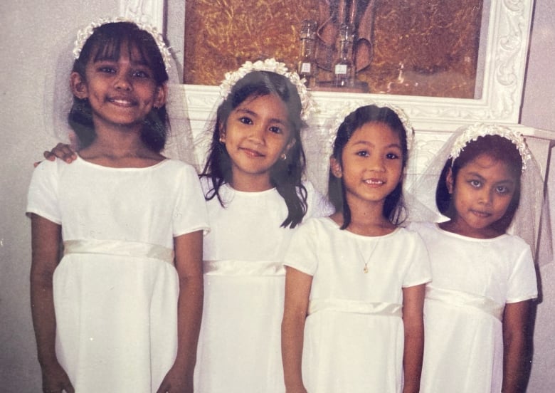 Four girls in white dresses at their first communion.