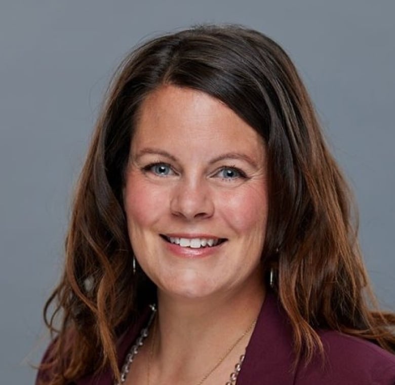 a woman with brown hair smiles.