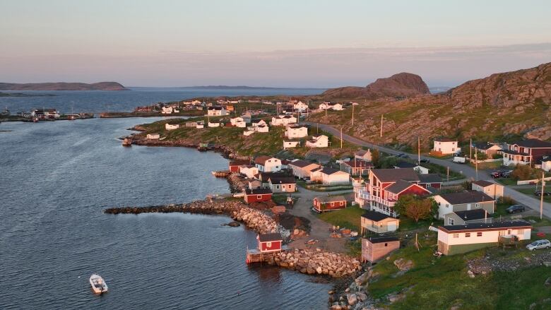 A scene of the ocean against the shore and a small town.