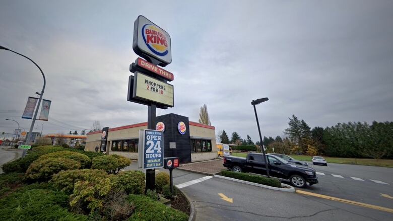 A Burger King restaurant with a drivethru sign reading 'Open 24 Hours'.