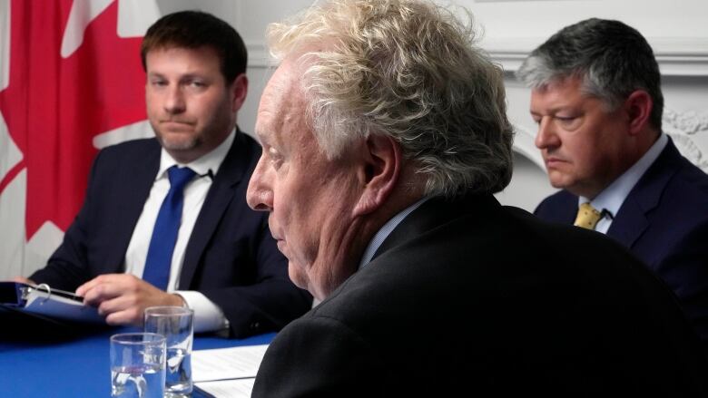 Conservative Leadership candidate Jean Charest, centre, speaks as Roman Baber, left, and Scott Aitchison look on at the Conservative Party leadership debate in Ottawa on Wednesday, August 3, 2022. 