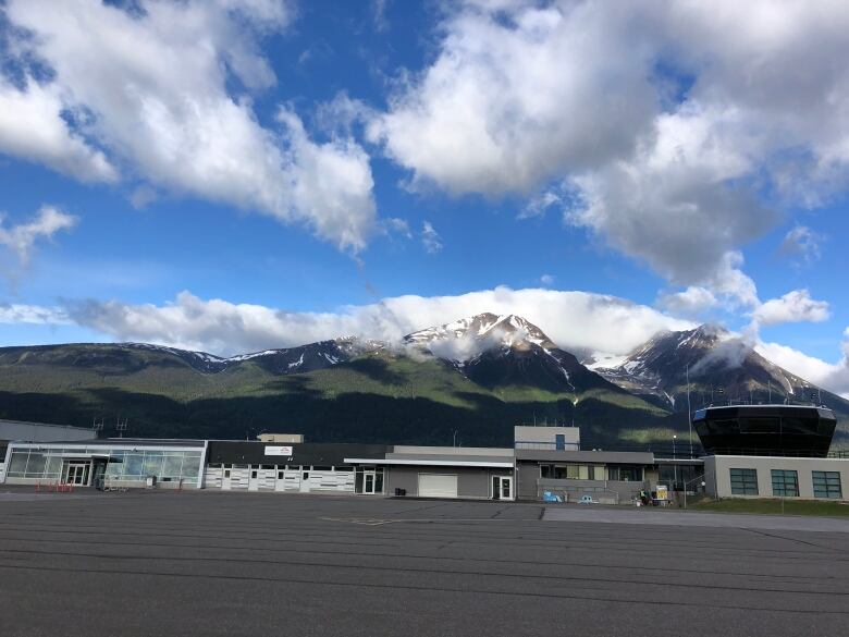 A small airport is seen in front of a mountain backdrop.