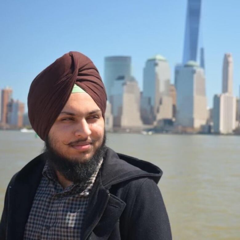 A man in a turban looks away from the camera