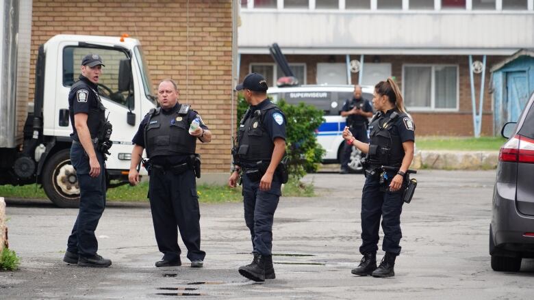 Police officers are standing and talking in a parking lot