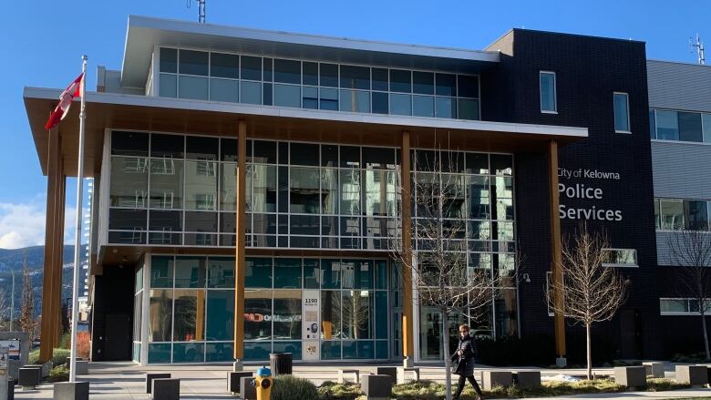 A large glass-fronted building with a sign on the right side that says City of Kelowna Police Services.