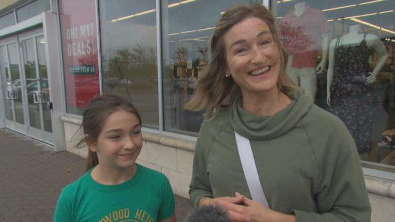 A mother and daughter stand outside a store in Ottawa Train Yards.