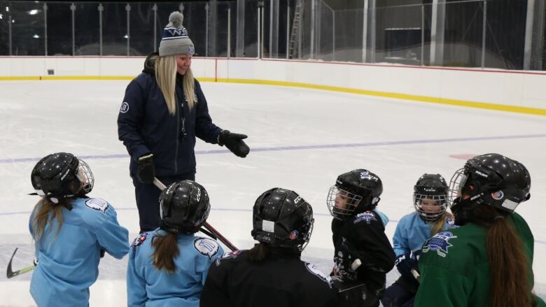 A woman coaches a hockey team.