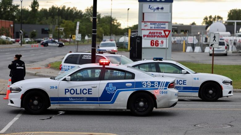 Police vehicles are parked on a street.