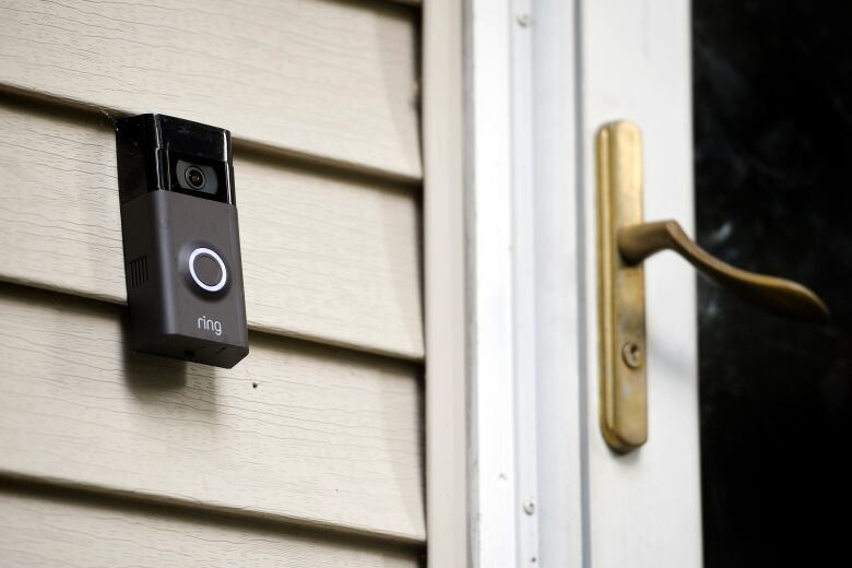 A black device with the word Amazon on it hangs beside a door