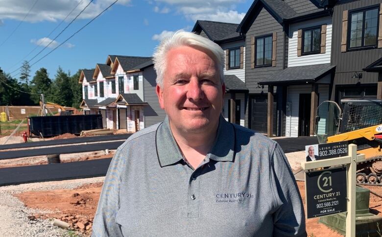 Realtor Joel Ives stands in front of a home for sale in Prince Edward Island