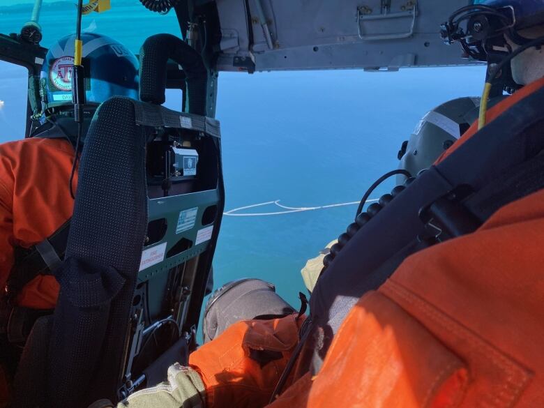 Coast Guard responders view a boom deployed below off San Juan Island, Washington. The United States Coast Guard says commercial divers are assessing a sunken fishing boat that went down Saturday in waters on the U.S. side of Haro Strait and is leaking fuel not far from southern Vancouver Island.