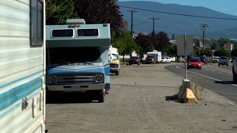 A number of RVs parked on a road.