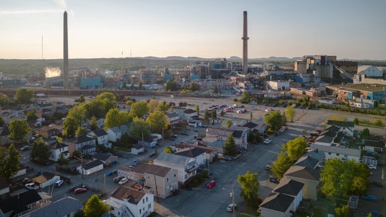 A photo from above of a residential neighbourhood adjacent to a large factory.