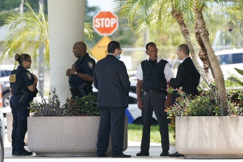 Law enforcement officers stand outside a courthouse.