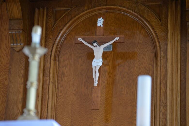 A crucifix on a wooden church wall.