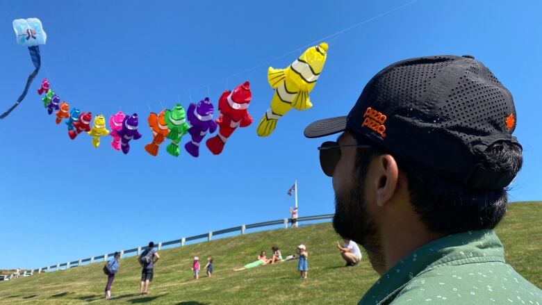 A man looks at kites.